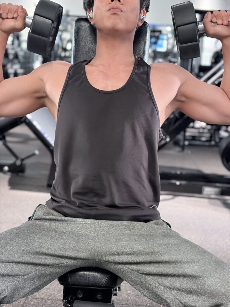ベンチに座ってダンベルで鍛える私